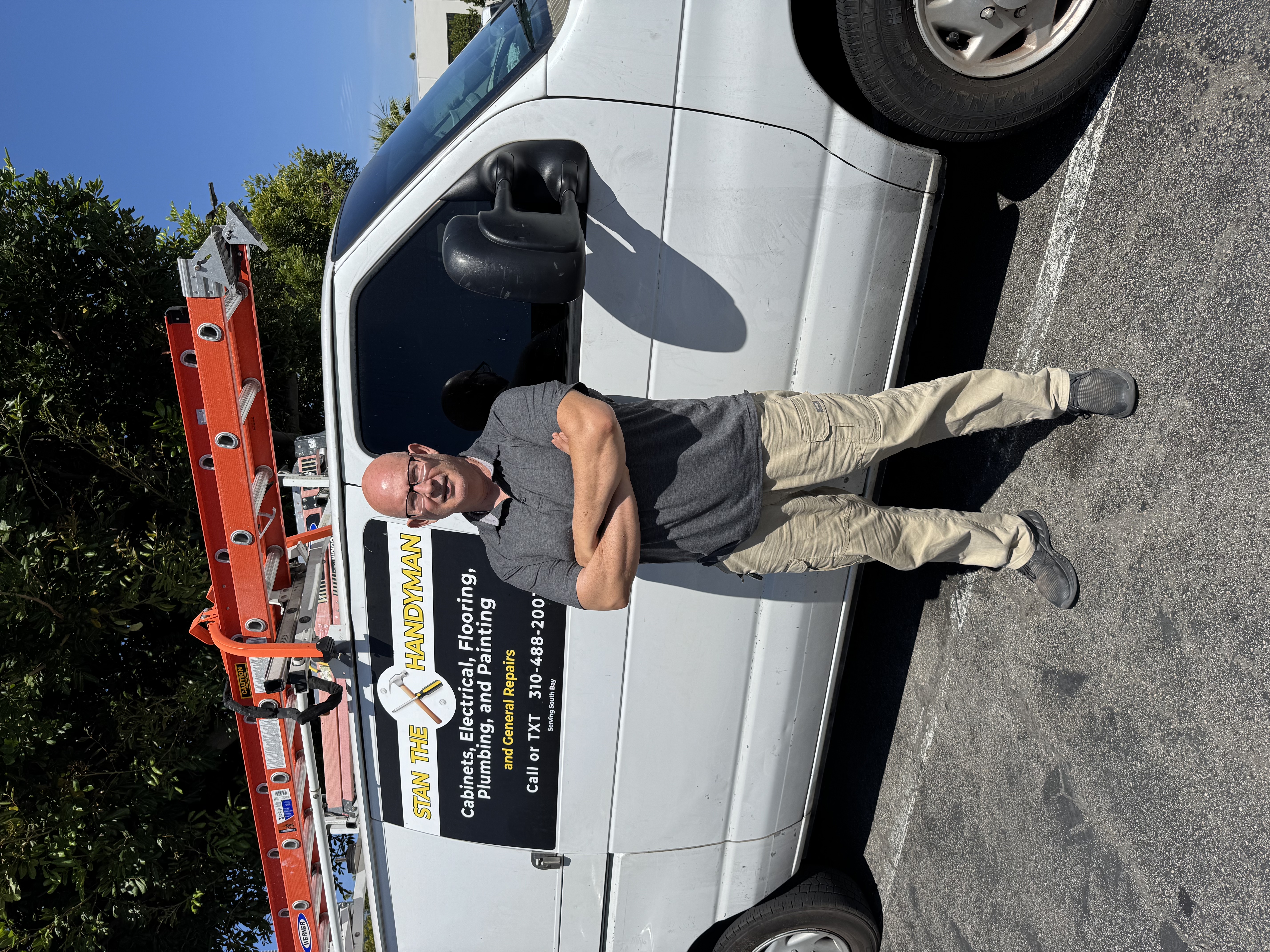 Stan — South Bay's trusted handyman, standing in front of his work van